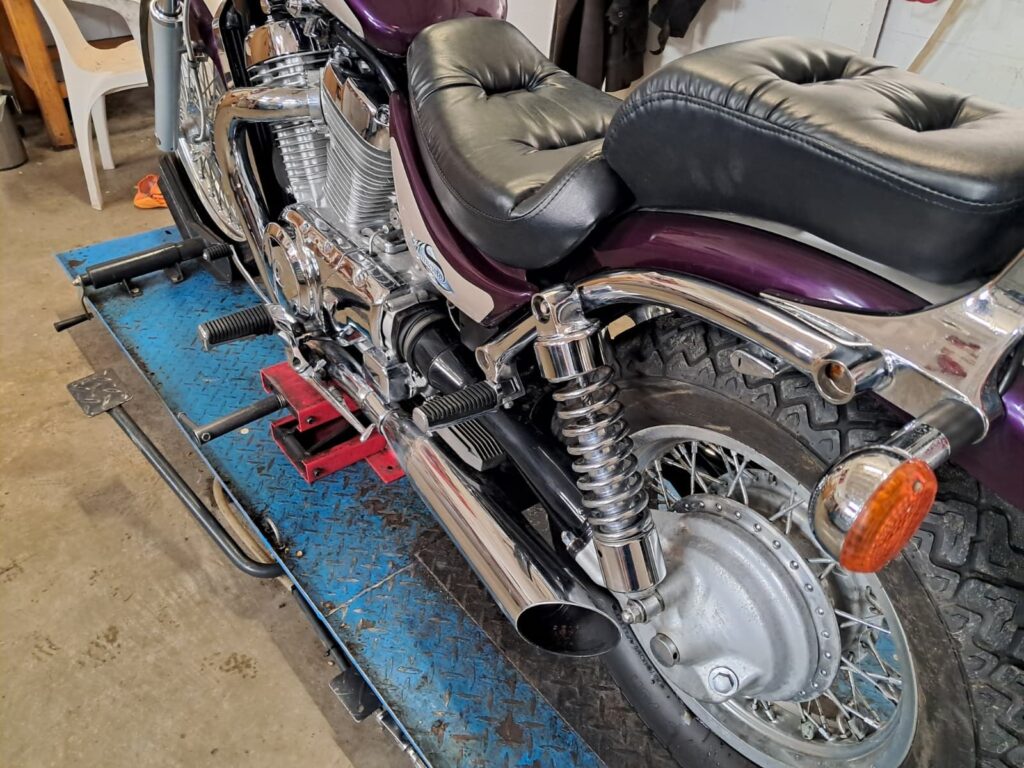 Paarse motor met chromen uitlaten in de werkplaats